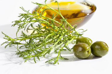 Olive herb with olives and olive oil on white background, close up - CSF019016