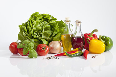 Salat mit Essig, Olivenöl, Peperonis, Tomaten und Pfefferkörnern auf weißem Hintergrund, Nahaufnahme - CSF018992