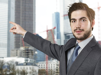 Portrait of young businessman pointing finger - STKF000271