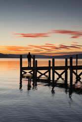 Deutschland, Baden Württemberg, Person auf Steg am Bodensee in der Abenddämmerung stehend - EL000010