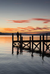 Germany, Baden Wuerttemberg, Person standing on pier at Lake Constance at dusk - EL000010