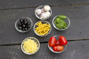 Variety of ingredients in bowl on wooden table, close up - SARF000040