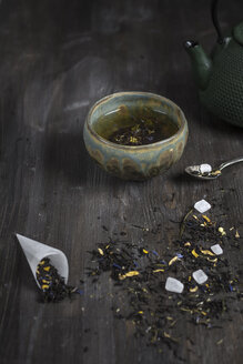 Japanische Teekanne und Schale mit Teeblättern auf Holztisch, Studioaufnahme - SBD000156