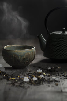 Japanische Teekanne und Schale mit Teeblättern auf Holztisch, Studioaufnahme - SBD000157