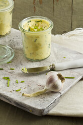 Knoblauch mit Kräutern und Butter auf einem Schneidebrett, Nahaufnahme - SBDF000059