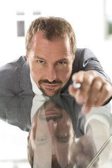 Germany, Portrait of businessman pointing, close up - MAEF006622