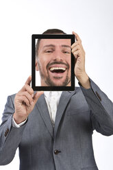 Portrait of businessman photographing self using digital tablet, smiling - MAEF006646