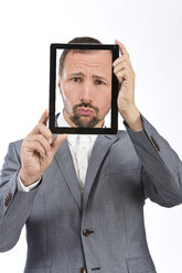 Portrait of businessman photographing self using digital tablet, close up - MAEF006647