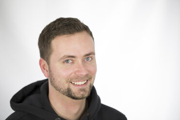 Portrait of mid adult man smiling against white background, close up - MABF000044