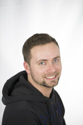 Portrait of mid adult man smiling against white background, close up - MABF000043