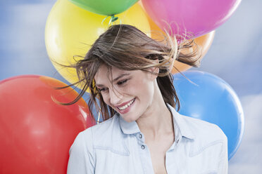 Deutschland, Köln, Junge Frau mit Luftballons, Nahaufnahme - FMKF000827