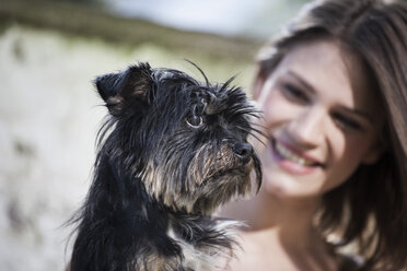 Deutschland, Köln, Porträt einer Frau mit ihrem Hund, lächelnd - FMKF000820