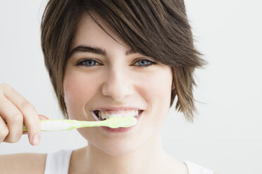 Germany, Bavaria, Munich, Portrait of young woman brushing teeth, close up - SPOF000402