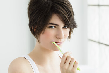 Germany, Bavaria, Munich, Portrait of young woman brushing teeth, close up - SPOF000404