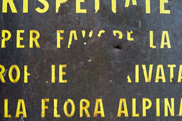 Italien, Altes schäbiges italienisches Schild über Alpenflora - SHF000716