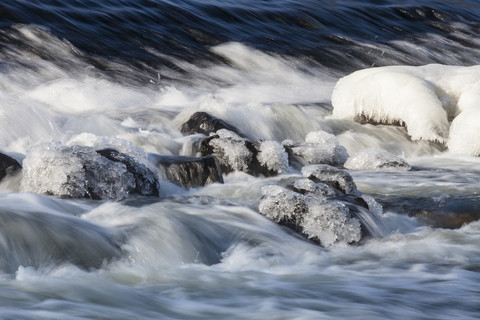 Deutschland, Hessen, Eis auf Felsbrocken im Fluss, lizenzfreies Stockfoto