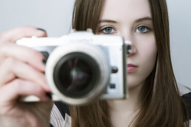 Portrait of Teenage girl holding digital camera - JAT000008
