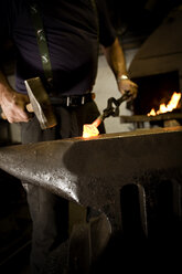 Blacksmith working with hammer at anvil - CNF000048