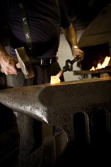 Schmied bei der Arbeit mit dem Hammer am Amboss - CNF000048