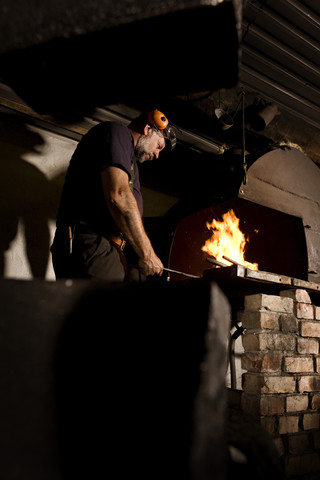 Schmied bei der Arbeit an der Feuerstelle, lizenzfreies Stockfoto