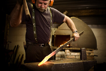 Schmied bei der Arbeit mit dem Hammer am Amboss - CNF000062