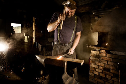 Schmied bei der Arbeit mit dem Hammer am Amboss - CNF000064