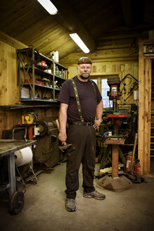 Porträt eines selbstbewussten Handwerkers in seiner Werkstatt - CNF000081