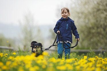 Germany, Baden Wuerttemberg, Portrait of girl walking with dog in meadow - SLF000126