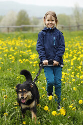 Deutschland, Baden Württemberg, Portrait eines Mädchens mit Hund auf einer Wiese - SLF000125