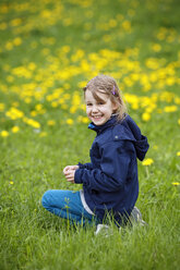 Germany, Baden Wuerttemberg, Portrait of girl sitting in meadow, smiling - SLF000134