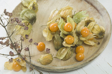 Physalis Früchte mit Holzteller auf weißem Hintergrund, Nahaufnahme - AS004944