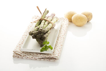 Bundle of green asparagus and potatoes, close up - MAEF006656