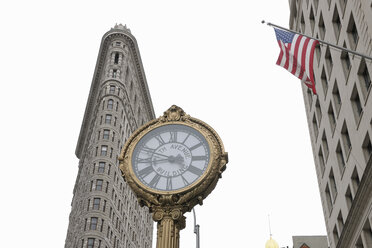 USA, New York State, New York City, View of Flatiron building with 5th Avenue clock and American flag at Manhattan - RUEF001033