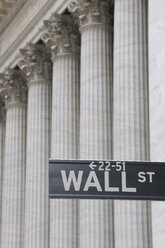 USA, New York State, Manhattan, Wall street sign against Stock Exchange pillars - RUEF001034