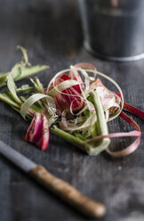 Peeled of rhubarb with knife on wooden table, close up - SBDF000083