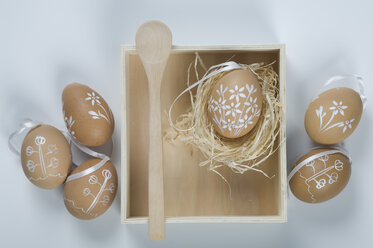 Painted easter eggs in box with straw and wooden spoon - ASF004954