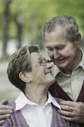 Germany, Cologne, Senior couple looking at each other in park, smiling - JAT000066