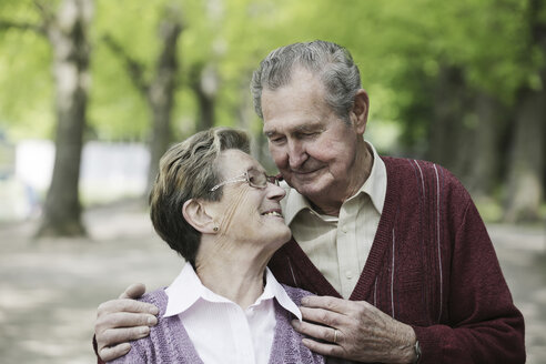 Deutschland, Köln, Älteres Paar sieht sich im Park lächelnd an - JAT000068