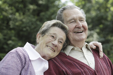 Germany, Cologne, Senior couple sitting in park, smiling - JAT000052