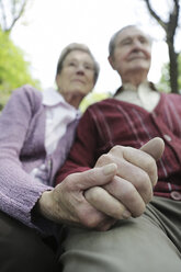 Germany, Cologne, Senior couple holding hands in park - JAT000056