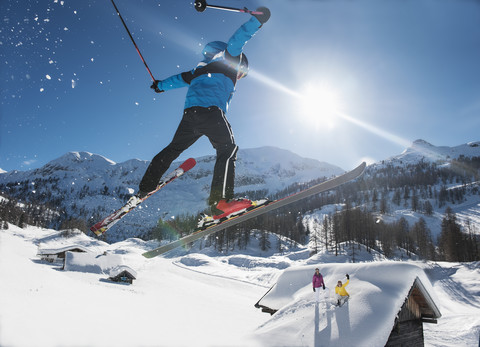 Österreich, Salzburg, Junger Mann beim Skispringen in den Bergen, lizenzfreies Stockfoto