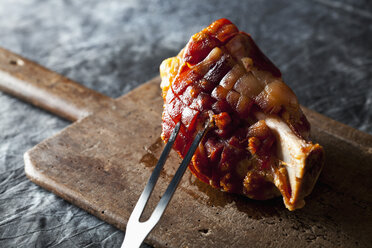 Gegrillte Schweinshaxe mit Gabel auf Schneidebrett, Nahaufnahme - CSF019311