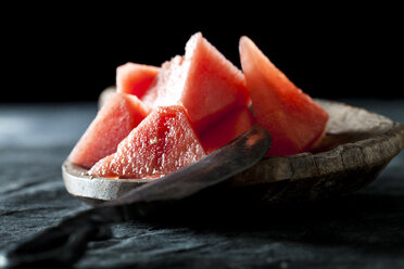 Slices of watermelon with knife on wooden spoon,close up - CSF019336