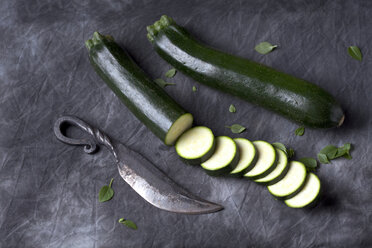 Zucchini mit Messer auf schwarzem Stoff, Nahaufnahme - CSF019358