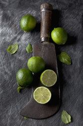 Limes with leaves and sickle on black textile, close up - CSF019347