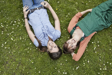 Germany, Cologne, Young women lying on grass, smiling - RHYF000394