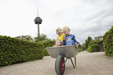 Germany, Cologne, Boys and baby girl in wheelbarrow - RHYF000451