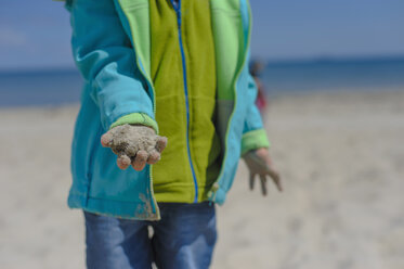 Deutschland, Mecklenburg Vorpommern, Junge spielt mit Sand an der Ostseeküste - MJF000183