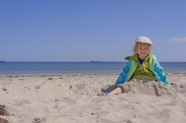 Deutschland, Mecklenburg Vorpommern, Junge spielt mit Sand an der Ostseeküste - MJF000203