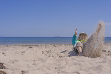 Deutschland, Mecklenburg Vorpommern, Junge spielt mit Sand an der Ostseeküste - MJF000188
